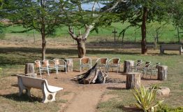Chairs_around_a_woodpile_in_the_garden_of_the_Ashnil_Aruba_Lodge_in_the_Tsavo_East_National_Park,_Kenya